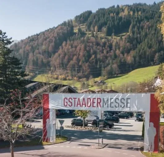 The Gstaader Messe banner spanning the entrance road, with an autumn hillside behind