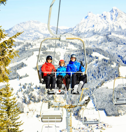Family riding a ski lift in Gstaad